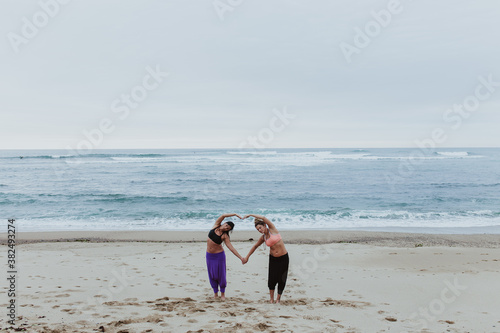 women doing yoga exersices on the beach photo