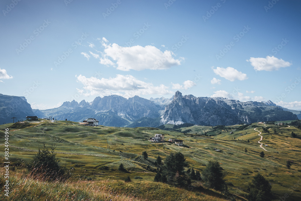 Summer scenery of Italian fields and mountains with many farms and cottages. 