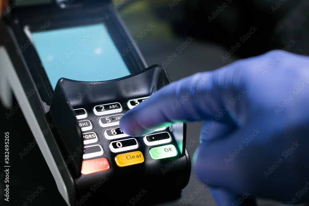 using POS terminal machine with a glove on hand using POS terminal machine with a glove on hand