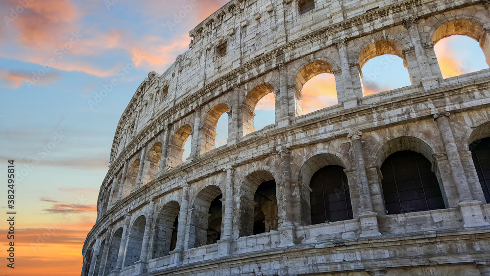 Obraz premium The Colosseum in Rome, Italy in the early evening with a colorful sky in the background.