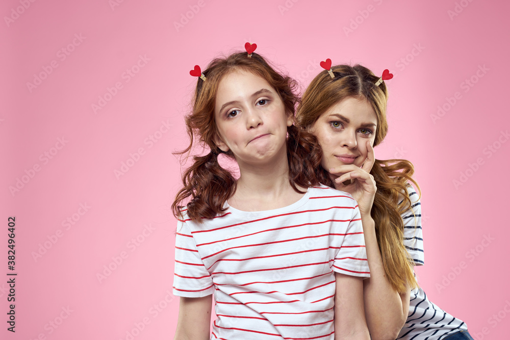 Cheerful mom and daughter lifestyle joy striped shirts family pink background Cheerful mom and daughter lifestyle joy striped shirts family pink background