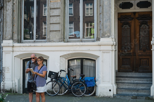 Middle age couple looking confused at map on city street photo