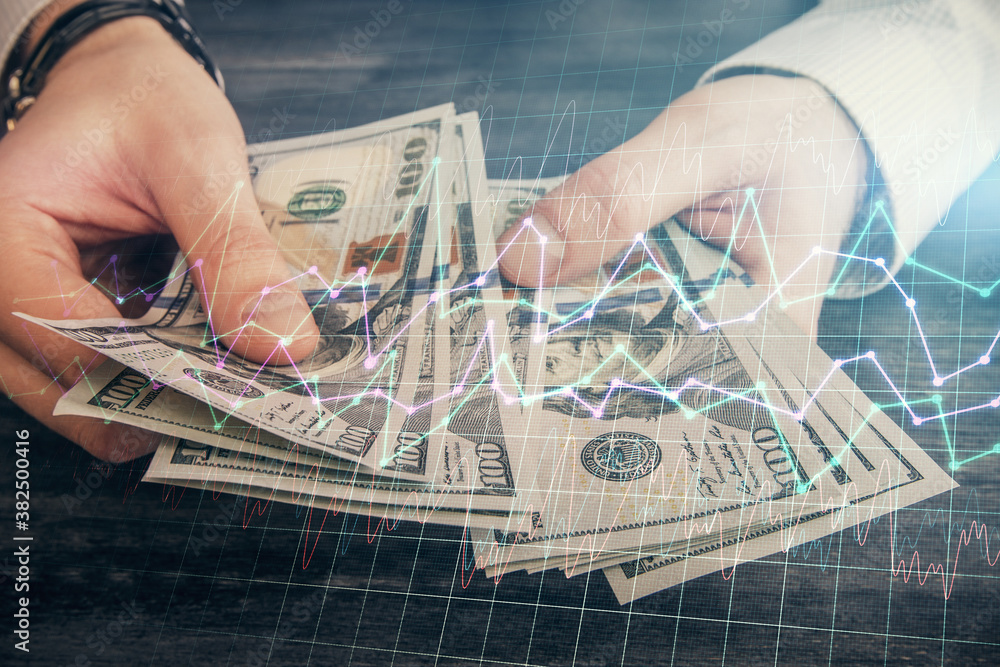 Multi exposure of financial graph drawing hologram and USA dollars bills and man hands. Analysis concept. Multi exposure of financial graph drawing hologram and USA dollars bills and man hands. Analysis concept.