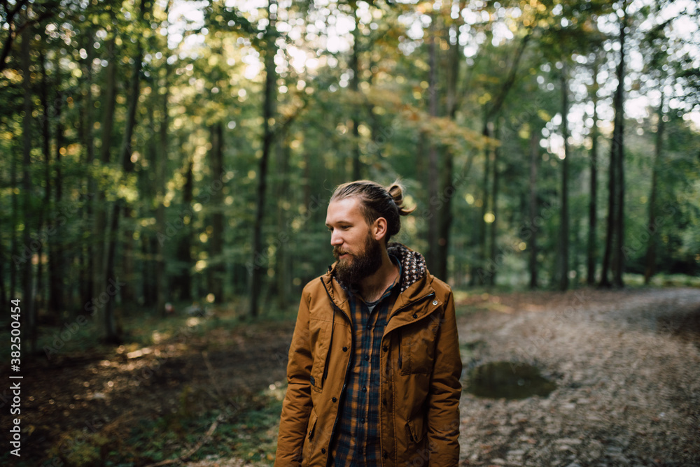 Young bearded man standing in the woods Young bearded man standing in the woods