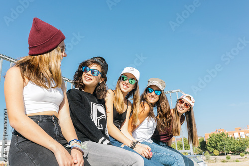 Five girls sitting close to each other.