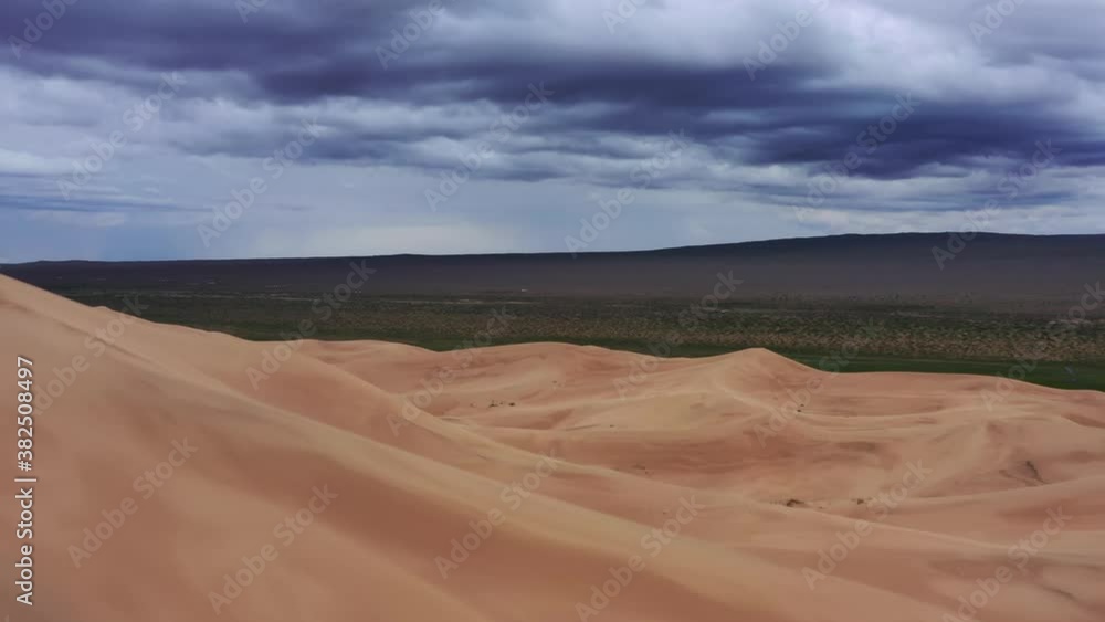 Aerial view on sand dunes with storm clouds at sunset in Gobi Desert, Mongolia, 4k Aerial view on sand dunes with storm clouds at sunset in Gobi Desert, Mongolia, 4k