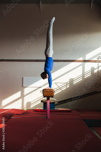 Male gymnast performing on pommel horse