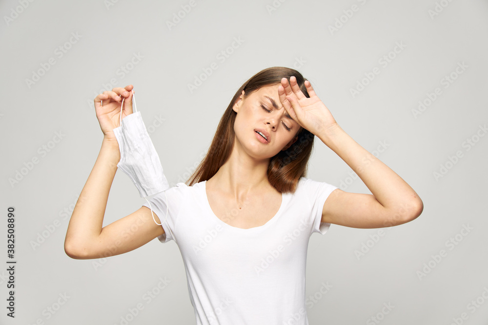 Girl closed eyes holding hand on forehead medical mask white t-shirt Girl closed eyes holding hand on forehead medical mask white t-shirt