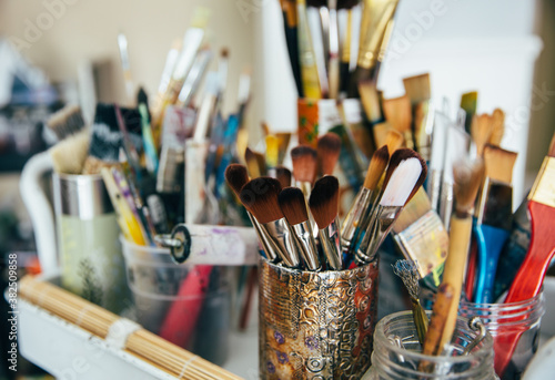 Paint brushes and supplies in an art studio photo