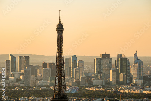 Eiffel Tower at sunset with La Defense skyline at background