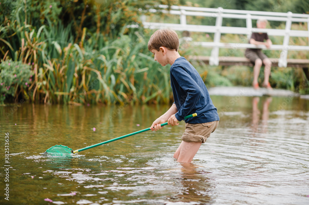 Child trying to catch fish with a fishing net