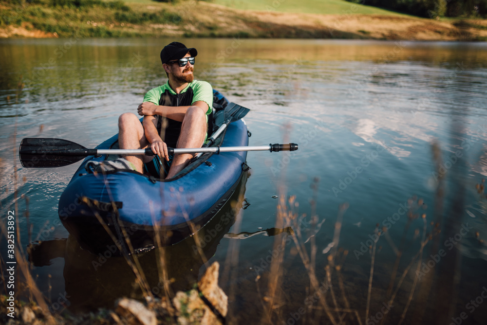 Adult man sitting in the boat with a paddle Adult man sitting in the boat with a paddle