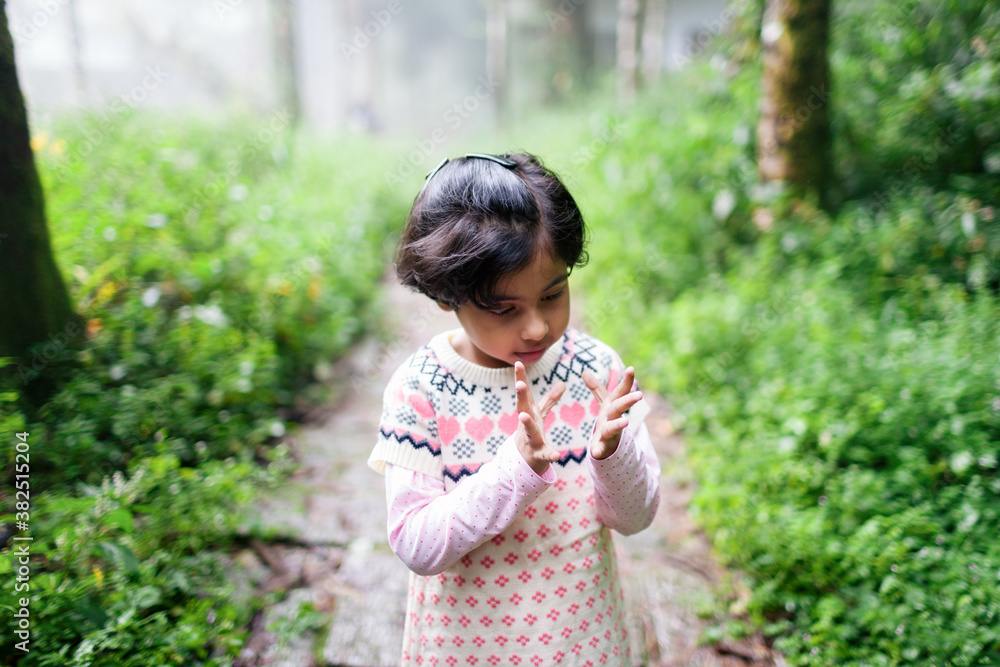 Little girl playing with her fingers in the forest Little girl playing with her fingers in the forest