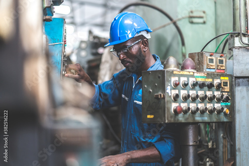 Male Engineer Working on laptop computer in Factory. black male engineer checking Quality control the condition of the machine. Service and maintenance of factory machinery