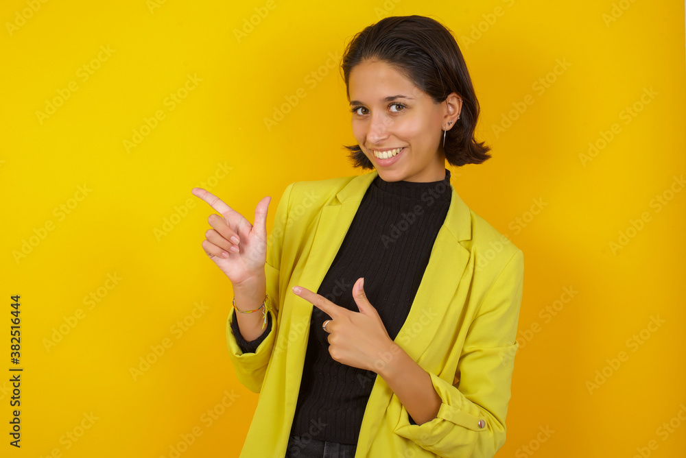 Young hispanic businesswoman wearing casual turtleneck sweater and jacket point at copyspace recommend sales discounts Young hispanic businesswoman wearing casual turtleneck sweater and jacket point at copyspace recommend sales discounts