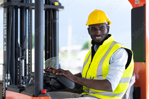 Warehouse man worker driver forklift. warehouse worker driver stacking card boxes by forklift in warehouse store. African American black people.