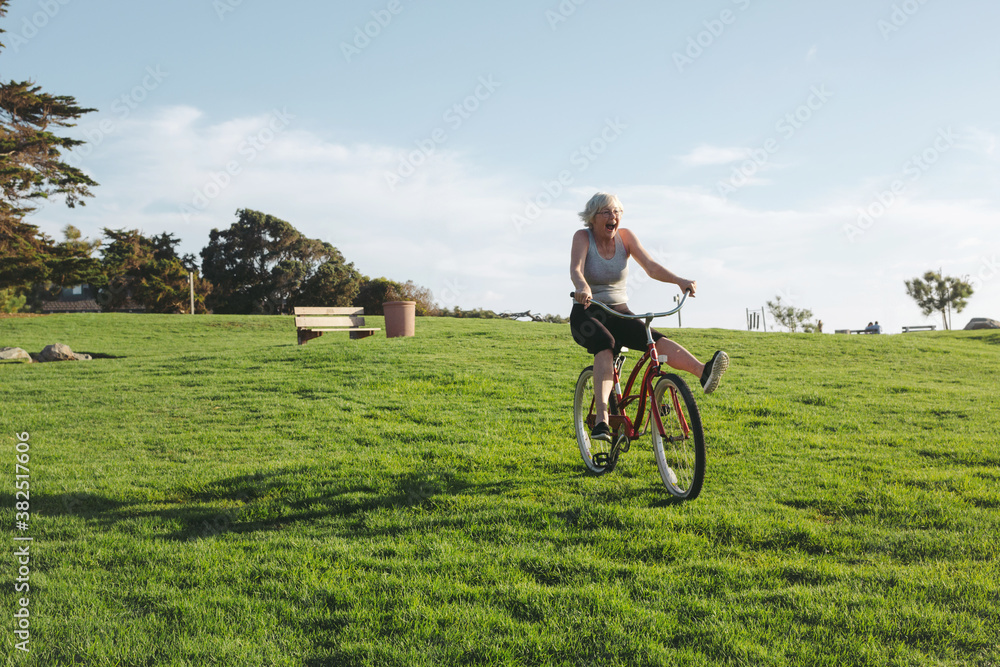 Vibrant mature woman enjoying herself on a bicycle Vibrant mature woman enjoying herself on a bicycle