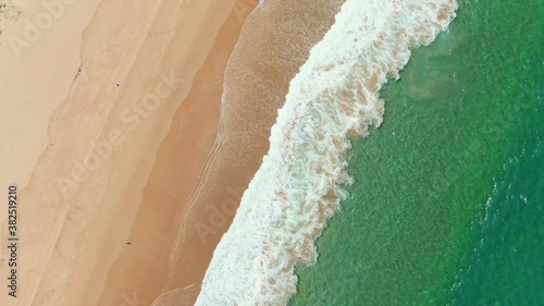 Aerial photography of turquoise waves rushing to the beach. Narrabeen Beach in Sydney, Australia. Rotating lens photo