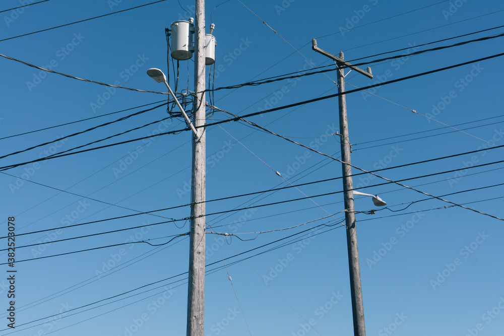 Telephone poles and power lines across blue sky Telephone poles and power lines across blue sky