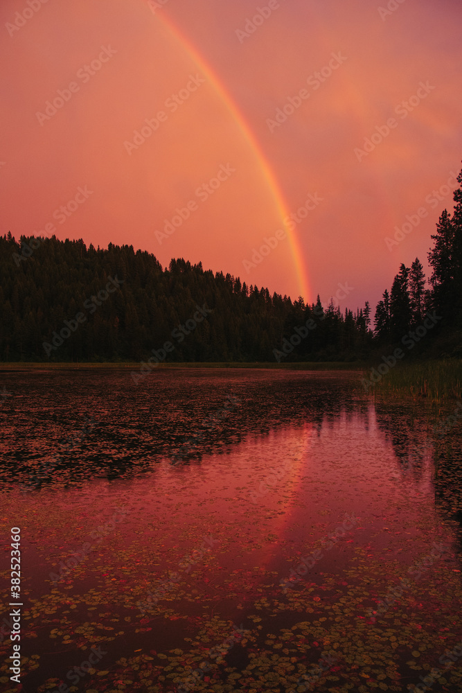 Rainbow with reflection at lake during sunset. Rainbow with reflection at lake during sunset.