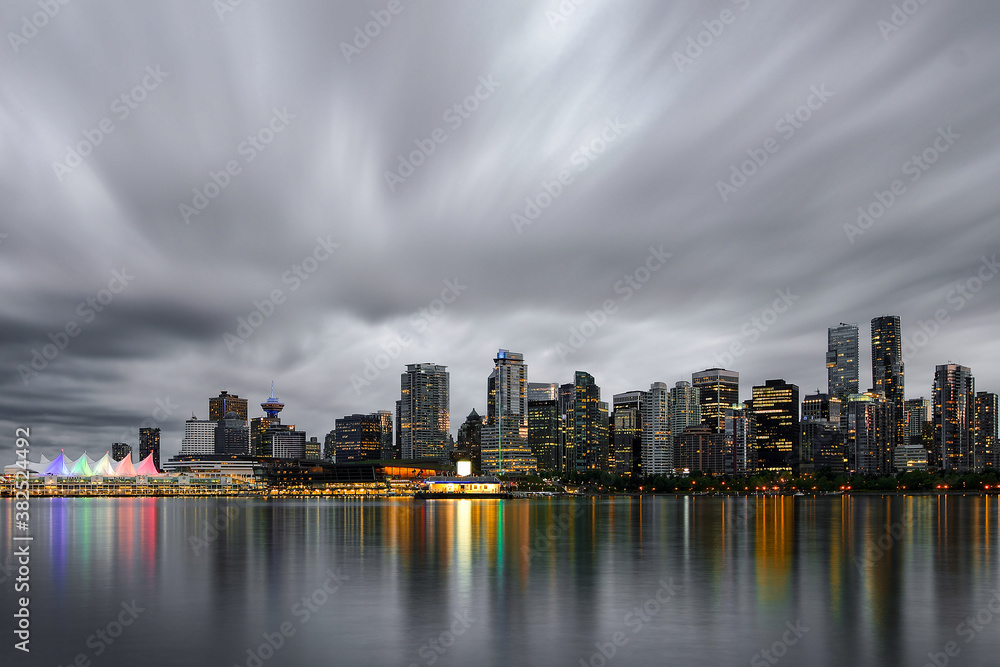 Dramatic night skyline with reflection of Vancouver Downtown as seen from Stanley Park, British Columbia, Canada Dramatic night skyline with reflection of Vancouver Downtown as seen from Stanley Park, British Columbia, Canada