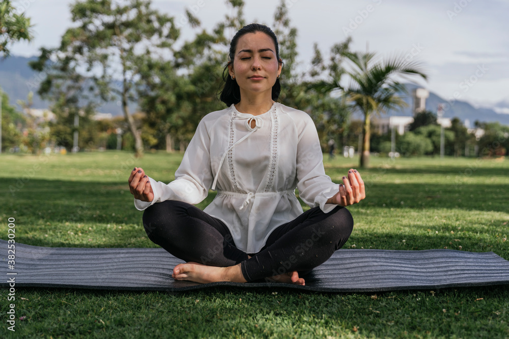 Woman doing yoga outdoors at a park Woman doing yoga outdoors at a park