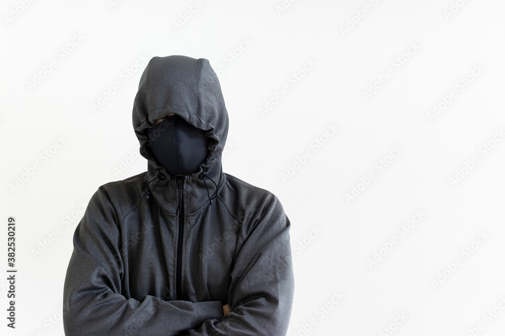 フードをかぶり、マスクをつけた怪しい男性 フードをかぶり、マスクをつけた怪しい男性