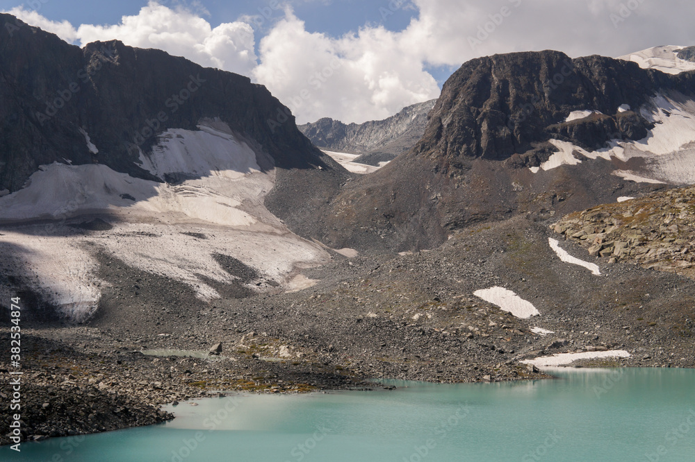 high mountains with snow stone with a blue lake