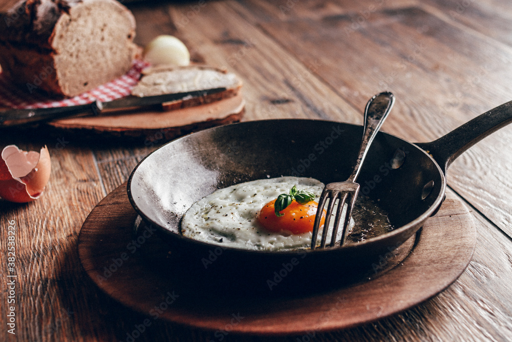 fried egg in cast iron pan on wooden background fried egg in cast iron pan on wooden background