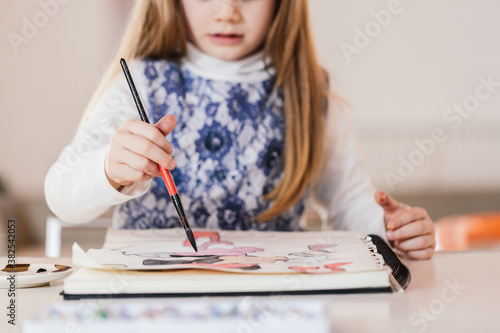 Young girl drawing at home photo