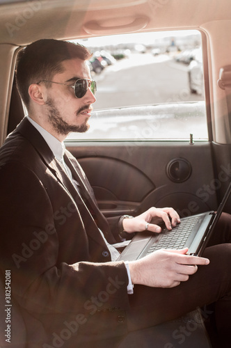 Businessman Driving in Backseat of Car photo