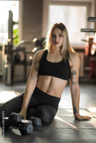 Young beautiful girl athlete posing in the fitness room.