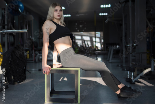 Young beautiful girl athlete posing in the fitness room.