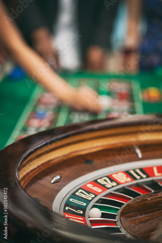 Casino: Focus On Ball In Numbered Slot On Roulette Wheel photo