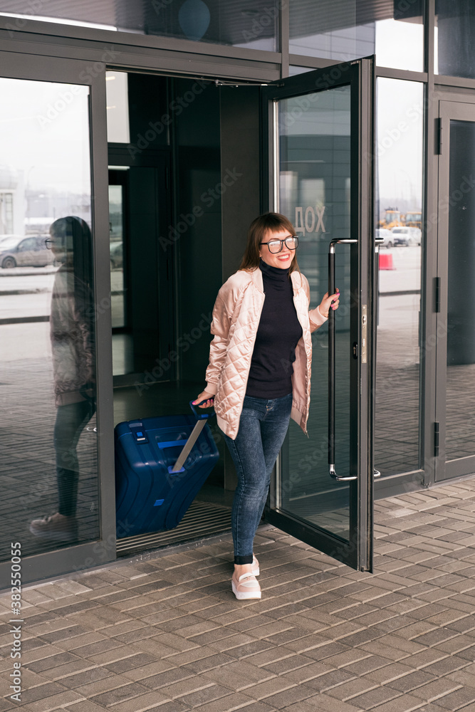 Happy woman going out from airport door Happy woman going out from airport door