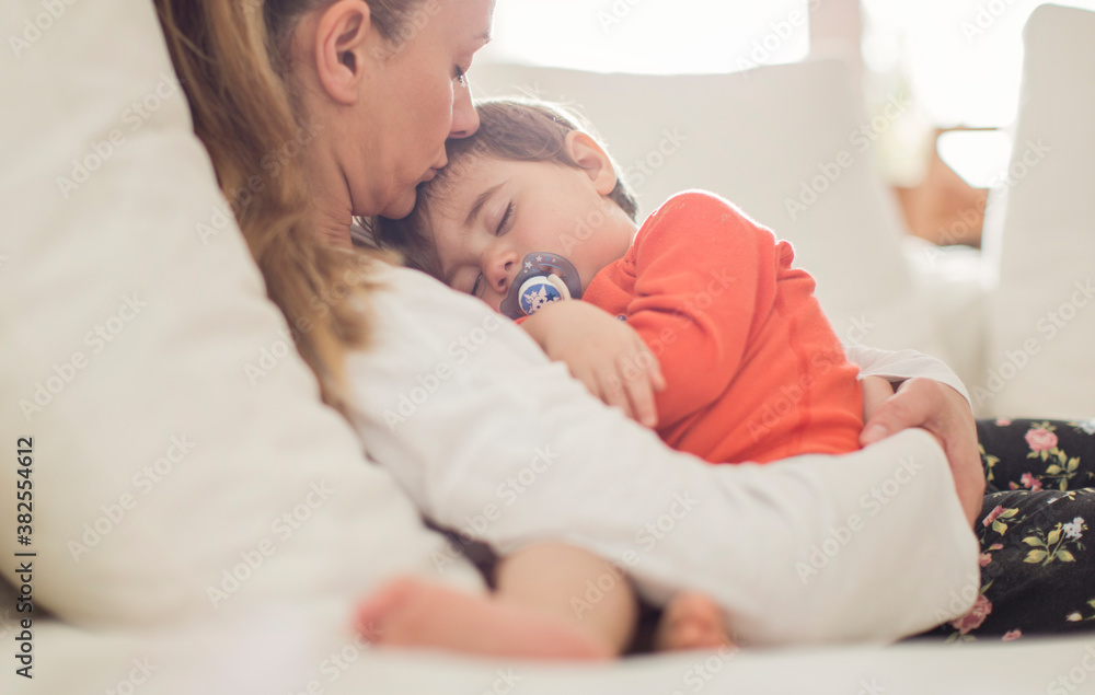 Mother kissing her small boy while his sleeping Mother kissing her small boy while his sleeping