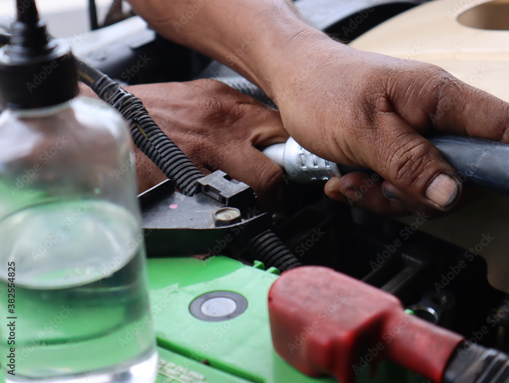 Mechanic working on the engine in an auto repair shop Mechanic working on the engine in an auto repair shop