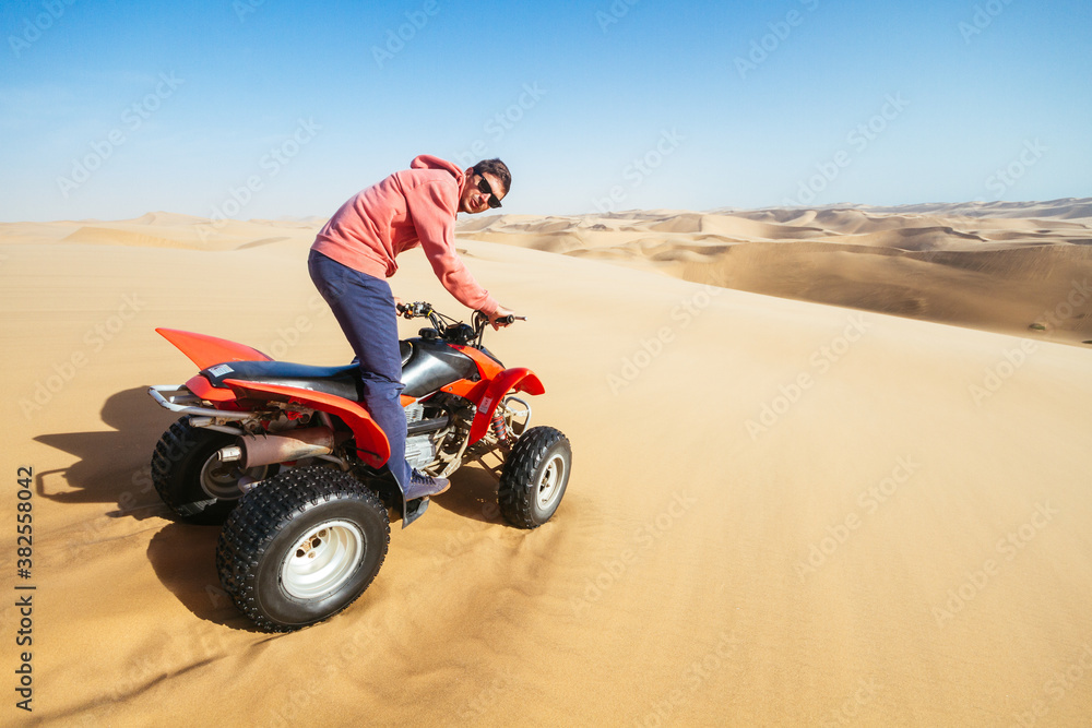Young man on quad bike in desert Young man on quad bike in desert