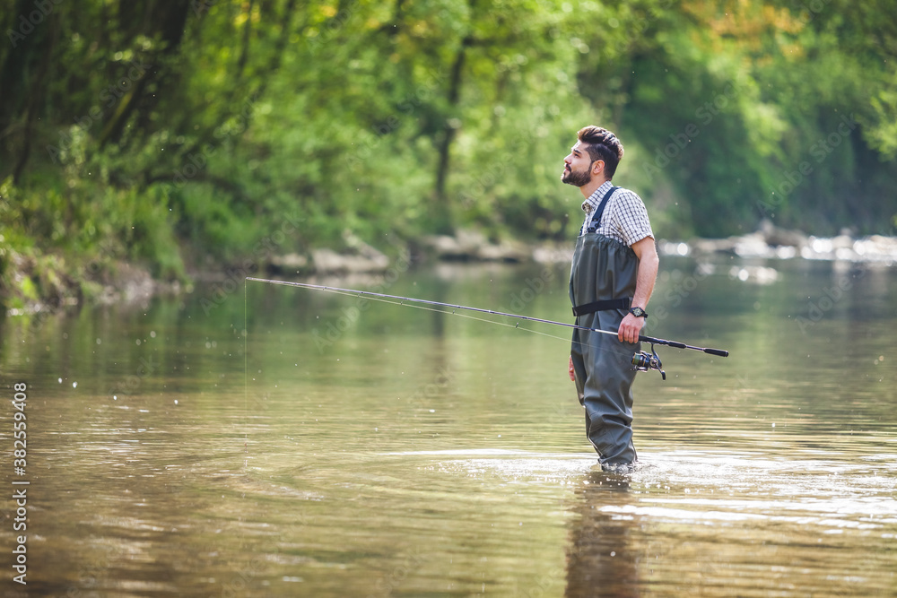 Young Fisherman Exploring the Wilderness in a Small River Young Fisherman Exploring the Wilderness in a Small River