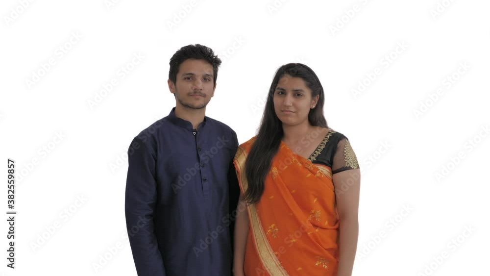 Young Indian couple pointing at camera in you gesture and calling someone with index finger. Beckoning sign. Come here. Isolated on white background Young Indian couple pointing at camera in you gesture and calling someone with index finger. Beckoning sign. Come here. Isolated on white background