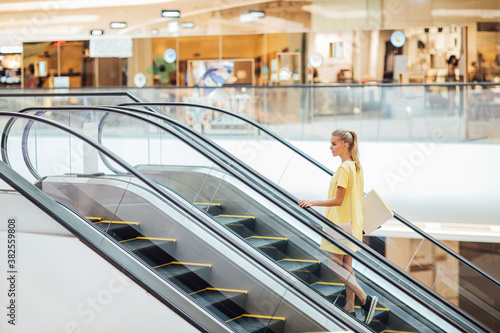 Caucasian Woman on an Escalator in the Shopping Mall photo