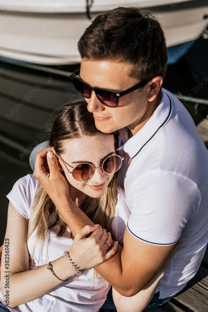 Portrait photo of happy young couple sit on the sea harbor
