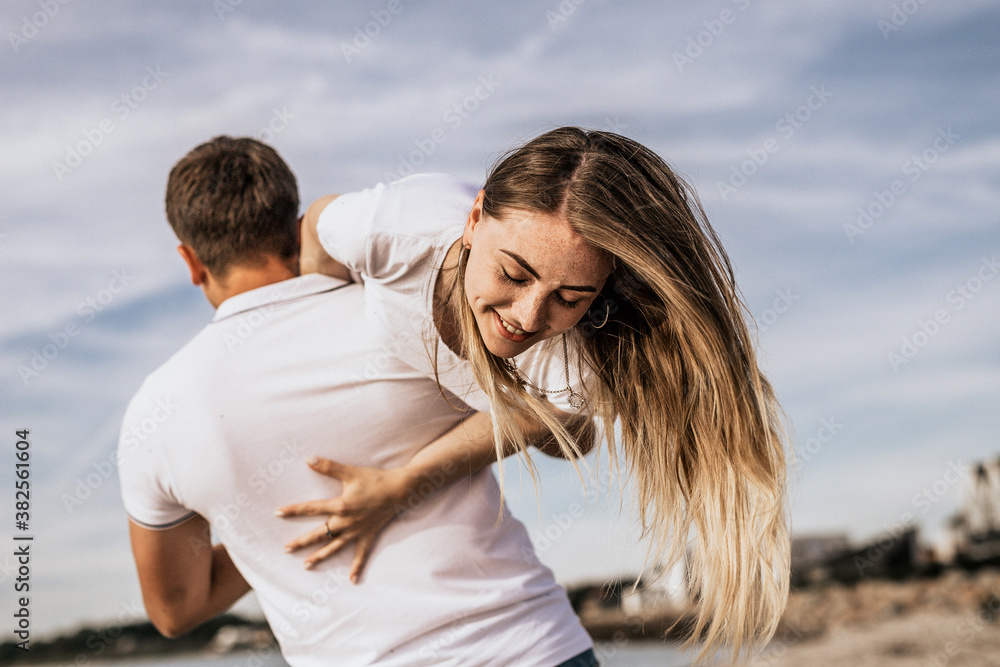 Happy couple having fun laughing on beach