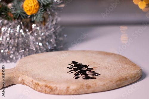 christmas tree made of chocolate on a wooden board next to new years decorations. 