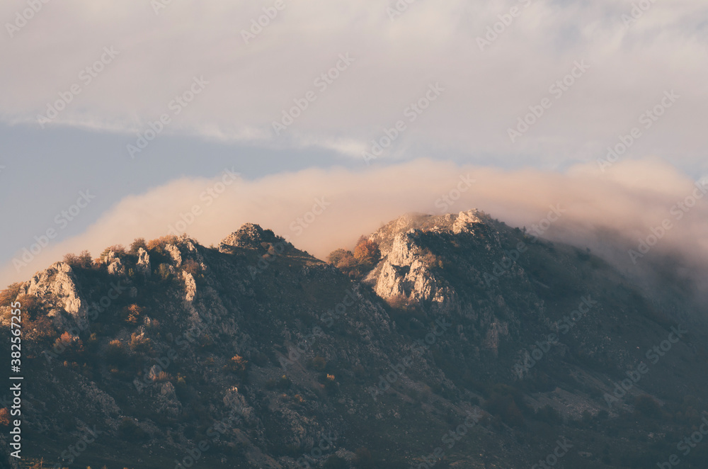 Mountain peak at sunset with fog Mountain peak at sunset with fog