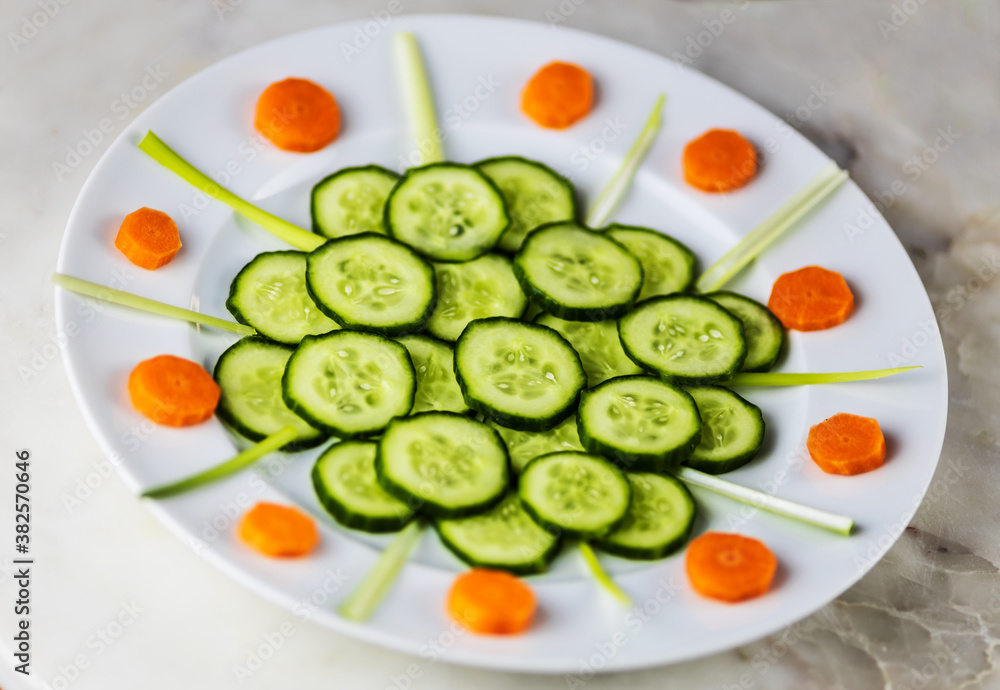 cucumber and carrot slices with chives on white plate cucumber and carrot slices with chives on white plate