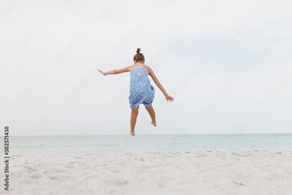 Girl jumping into air on the beach Girl jumping into air on the beach