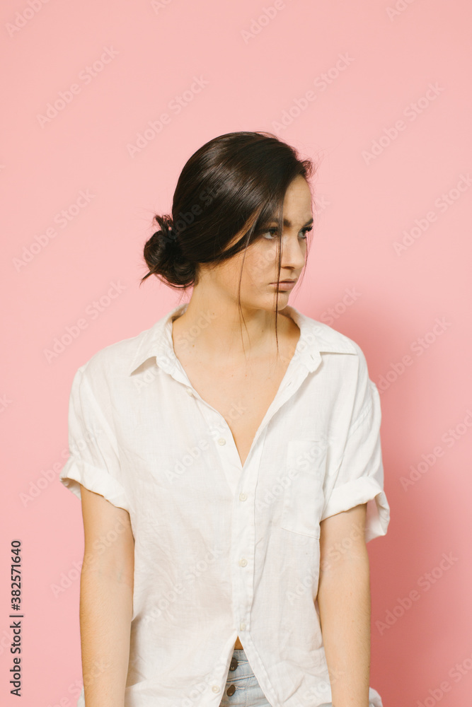 Pretty Girl Against Pink Wall with a Bun Pretty Girl Against Pink Wall with a Bun