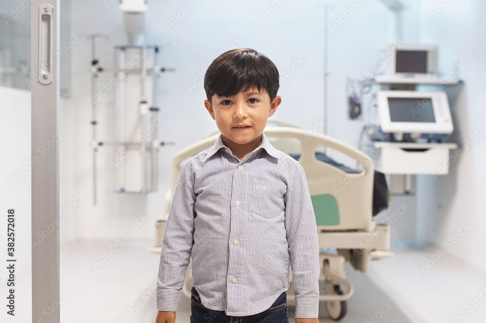 Young boy standing on the entrance to a hospital room Young boy standing on the entrance to a hospital room