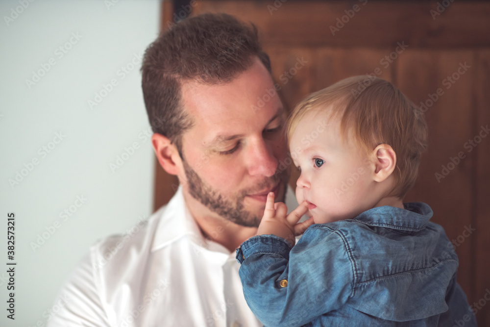 Handsome young father holding her baby in his arms Handsome young father holding her baby in his arms